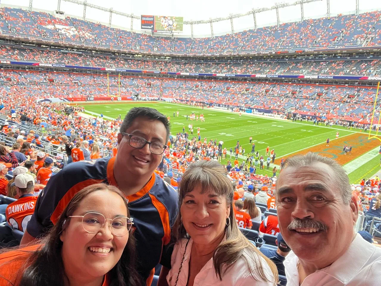 Mauricio, Lucy, la tía Mary y el tío César sonriendo en sus asientos con el campo al fondo